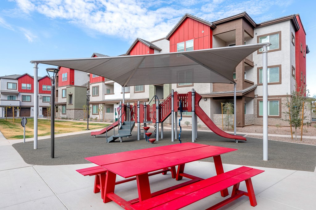 A playground with a red picnic table and slide. at Weylyn Luxury Apartments, Laveen