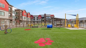 A playground with a blue tarp and red flower pattern on the grass.