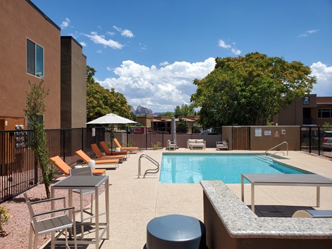 A pool area with chairs and a table.