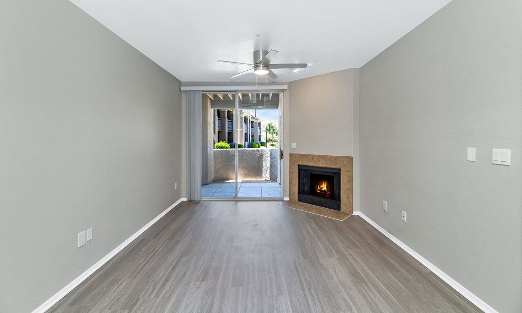 A room with a fireplace and a ceiling fan.