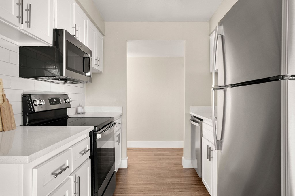 a kitchen with white cabinets and black appliances