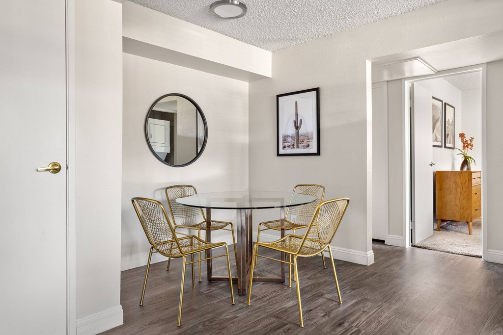 a dining area with a glass table and yellow chairs