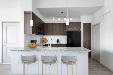 a kitchen with a marble counter top with three stools