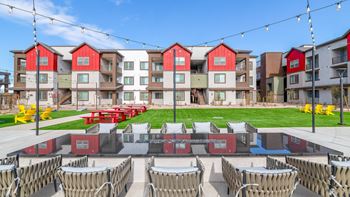 A row of red and white buildings with a lawn in front.