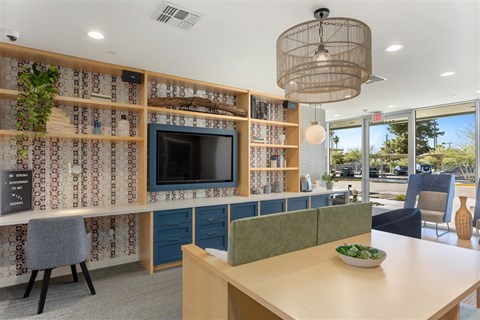 A conference room with a long table, chairs, and a television on a wall with a patterned wallpaper.at The 89 on Hayden, Arizona, 85257