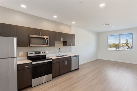 A modern kitchen with wooden cabinets and stainless steel appliances.