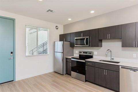 A kitchen with a blue door and stainless steel appliances.at The 89 on Hayden, Scottsdale  