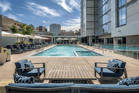 A large outdoor pool area with lounge chairs and umbrellas.