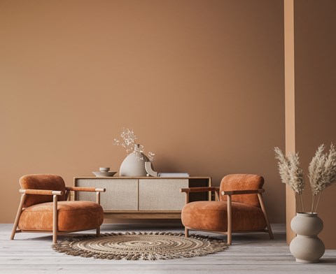 A living room with a sofa, two chairs, and a table with a vase on it.
