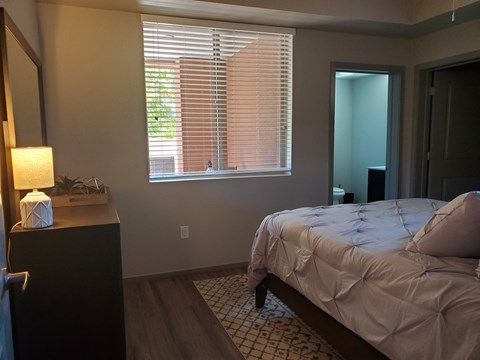 Bedroom with ensuite bathroom and wood flooring at Pinon Lofts Apartments, Arizona, 86336
