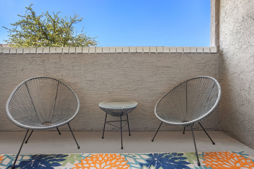 a patio with two chairs and a small table