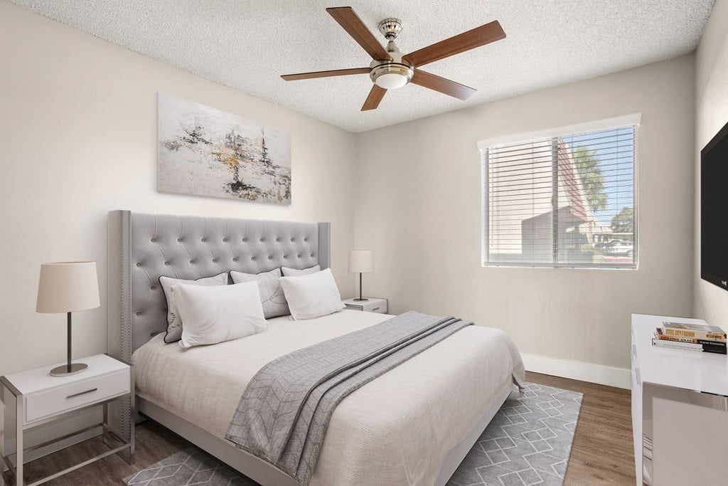 a bedroom with a large bed and a ceiling fan