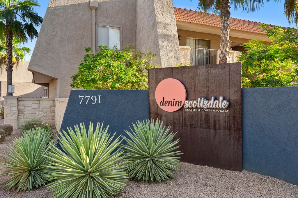 a sign in front of a building with palm trees in the background