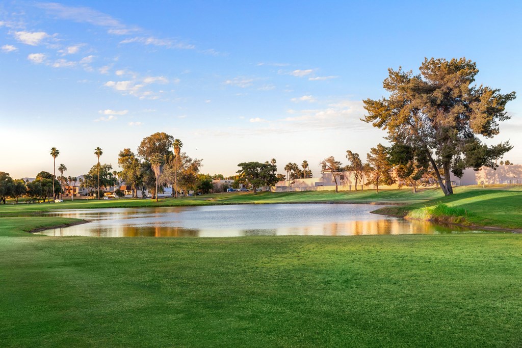a golf course with a pond in the middle of it