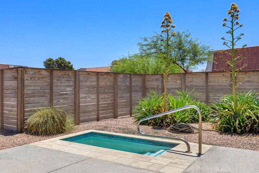 a pool and hot tub in the backyard of a house