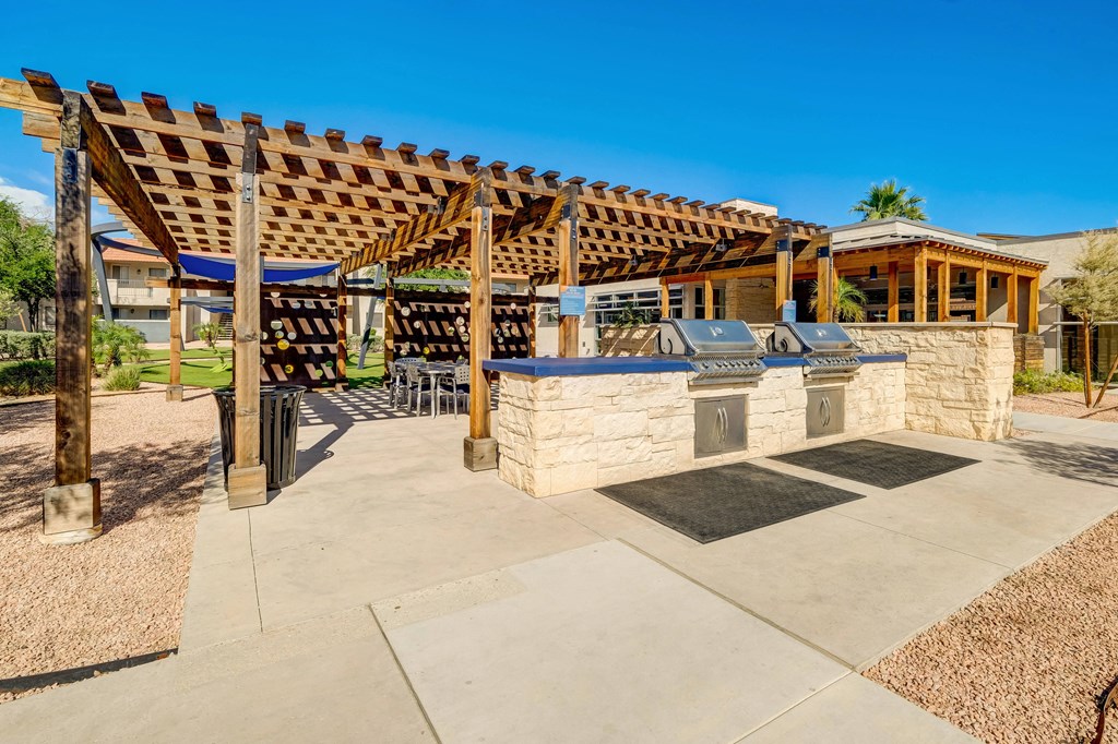 the backyard has a patio with a stone grill and a pergola