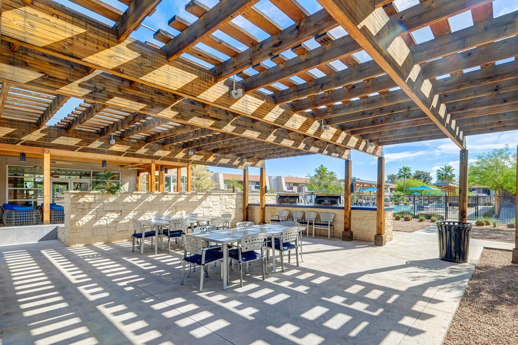 a patio with tables and chairs and a pergola