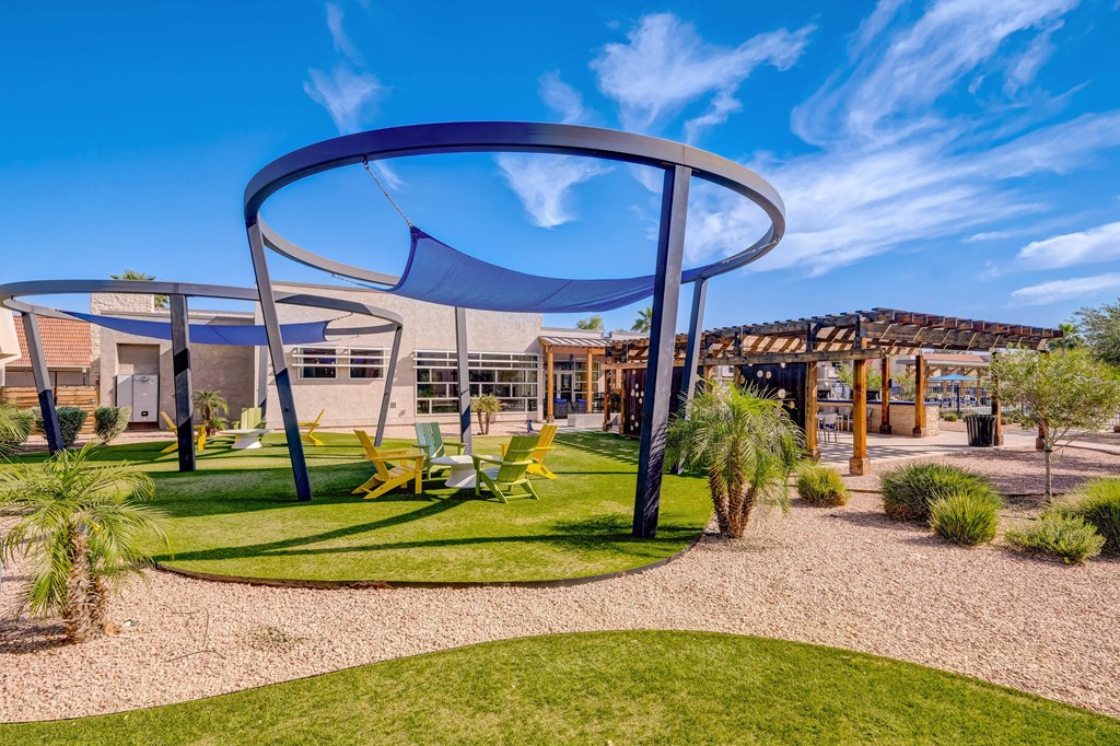 a playground with chairs and a canopy in front of a building