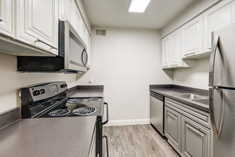 a kitchen with stainless steel appliances and white cabinets