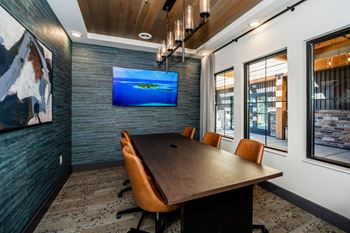 A conference room with a long table and chairs.