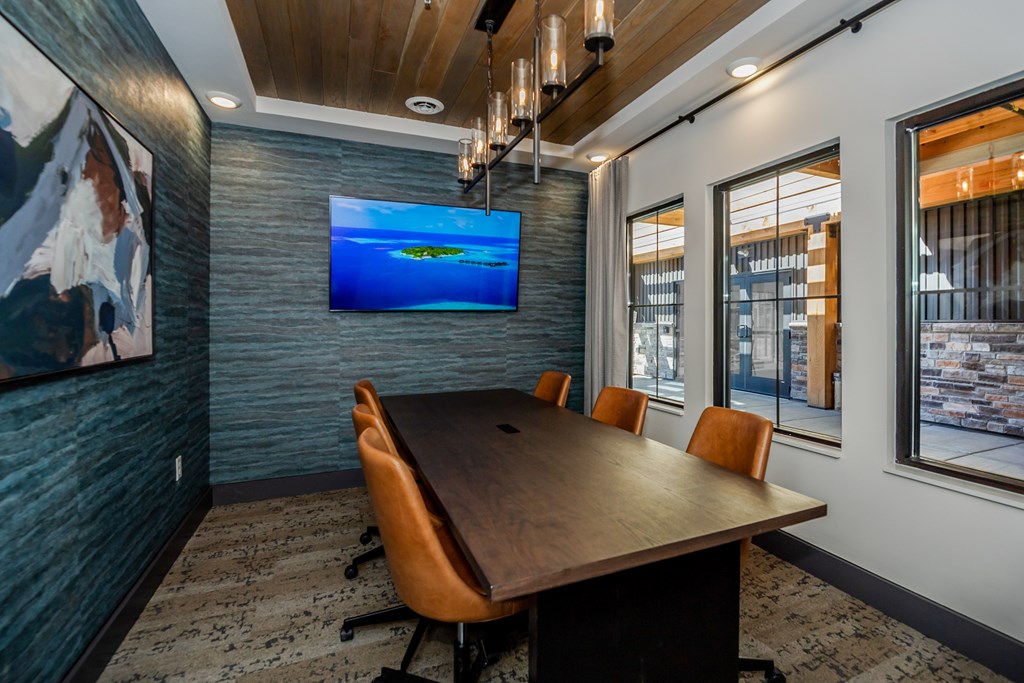 A conference room with a long table and chairs.