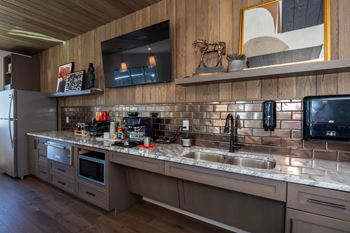 A modern kitchen with a wooden ceiling and a large island with a sink.