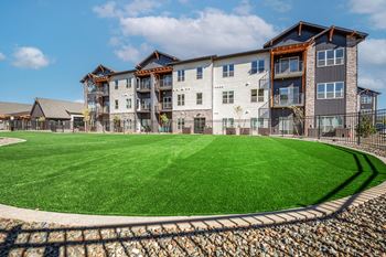 A large grassy area in front of a multi-story building.