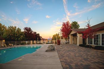 a swimming pool with chairs next to a house