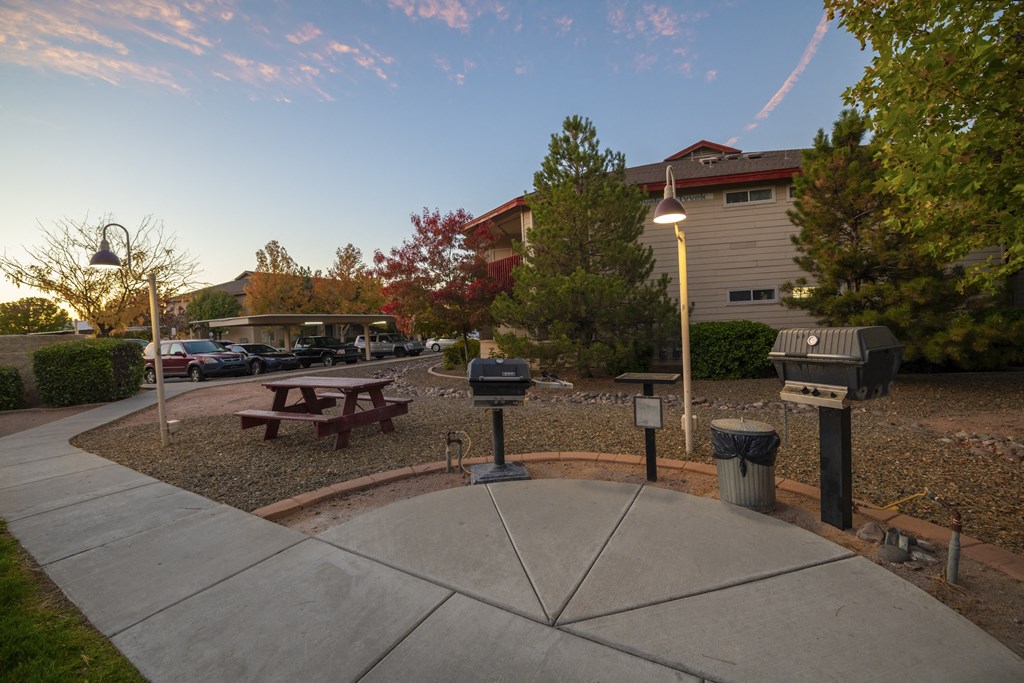 a park with a picnic table and a fountain in front of a building