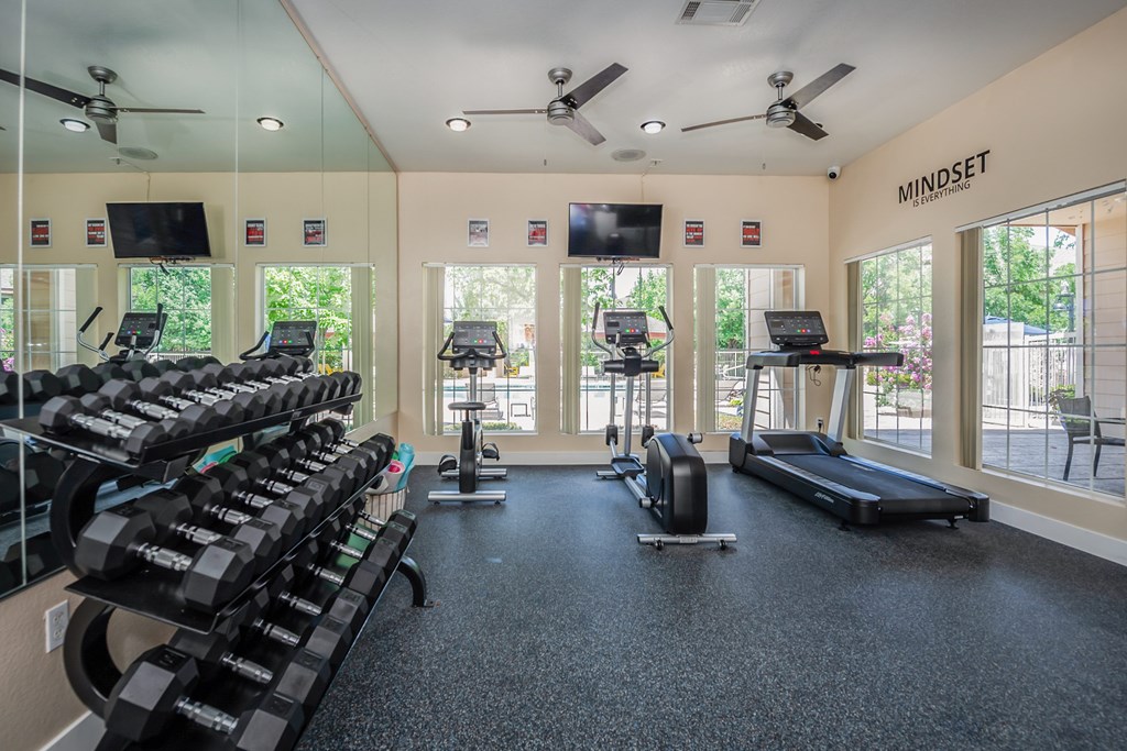 A gym with treadmills, exercise bikes, and a rowing machine.