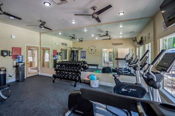 A gym with treadmills, elliptical machines, and a rowing machine.