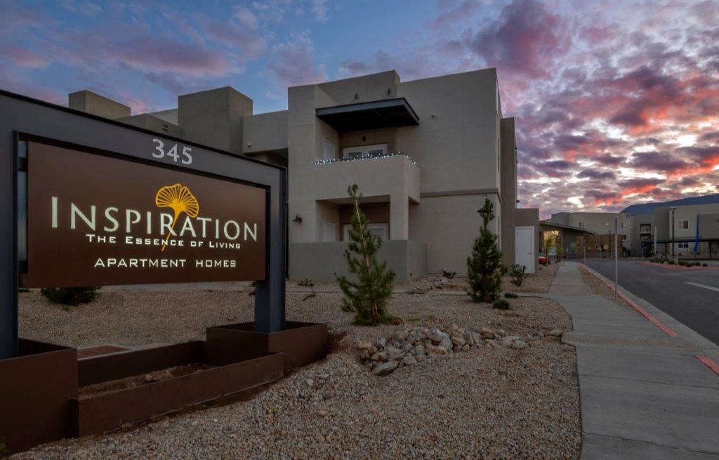 a sign in front of a building with a sunset behind it at Inspiration Apartments, Cottonwood, AZ, 86326
