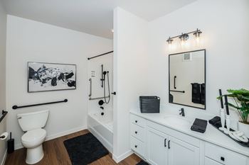 A bathroom with a toilet, sink, and mirror.