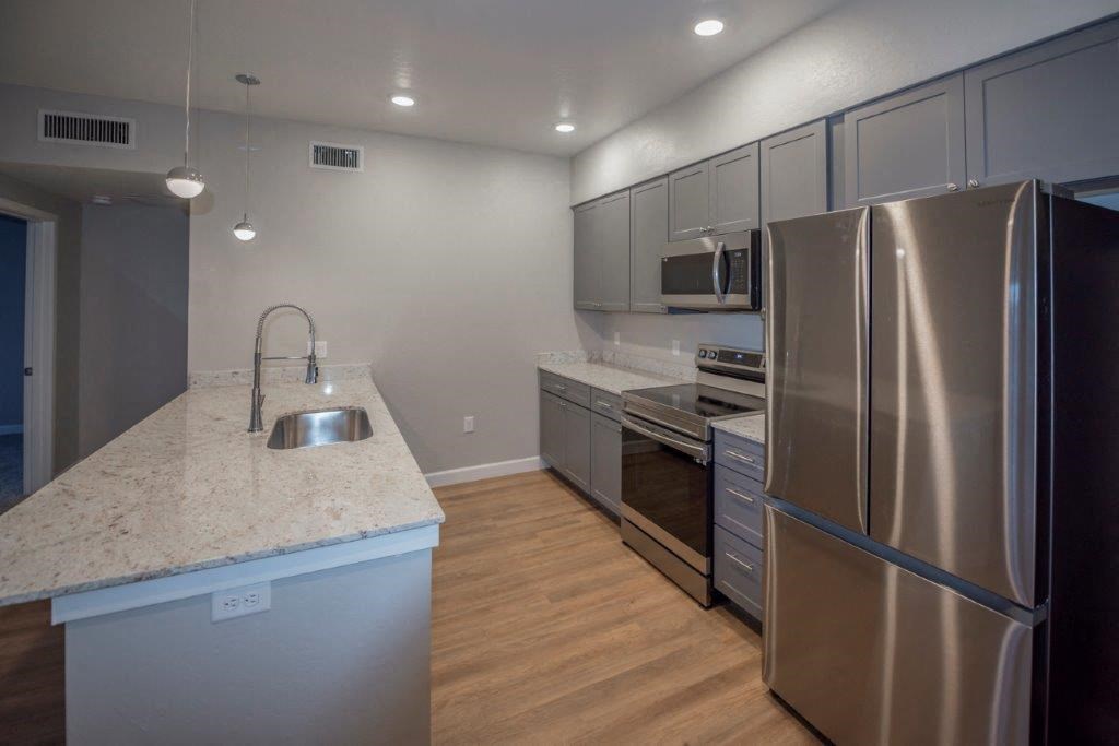 a kitchen with stainless steel appliances and a marble counter top at Inspiration Apartments, Arizona