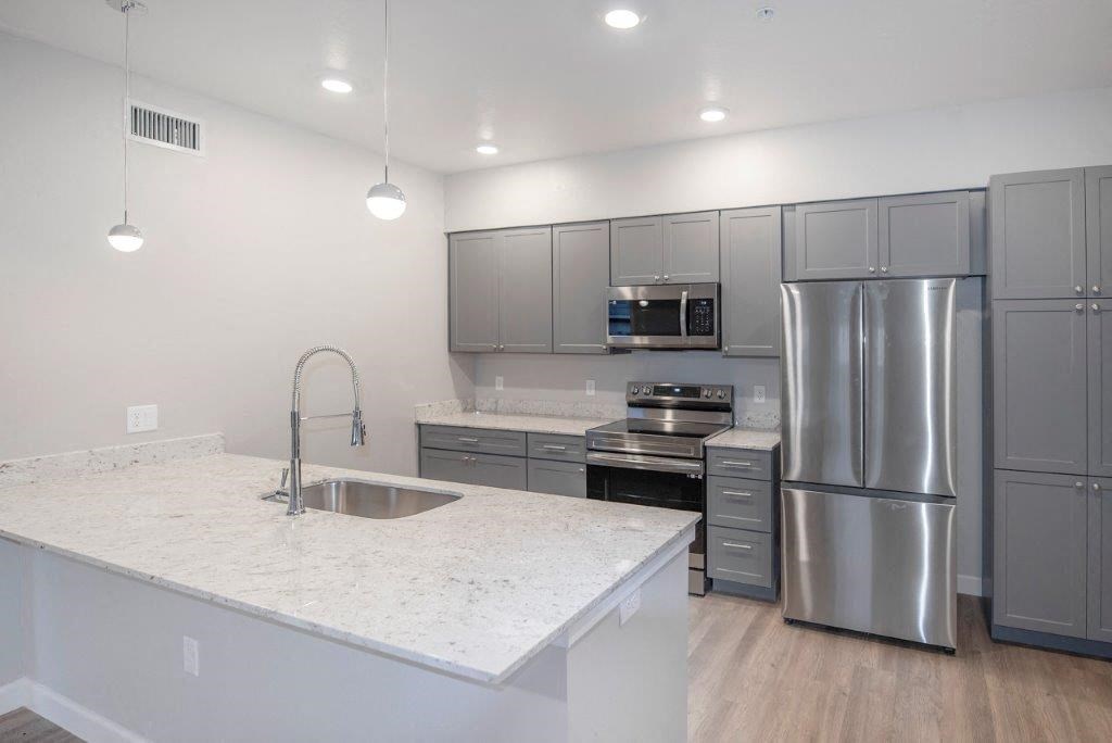a kitchen with stainless steel appliances and a marble counter top at Inspiration Apartments, Cottonwood, 86326