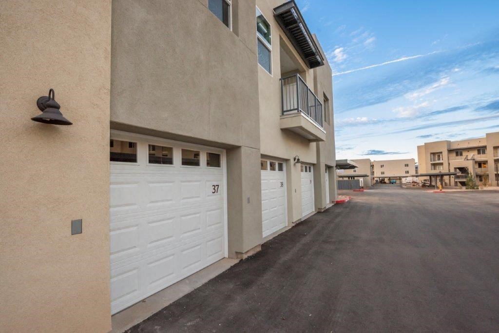 an empty parking lot with a building with white garage doors at Inspiration Apartments, Cottonwood, AZ, 86326