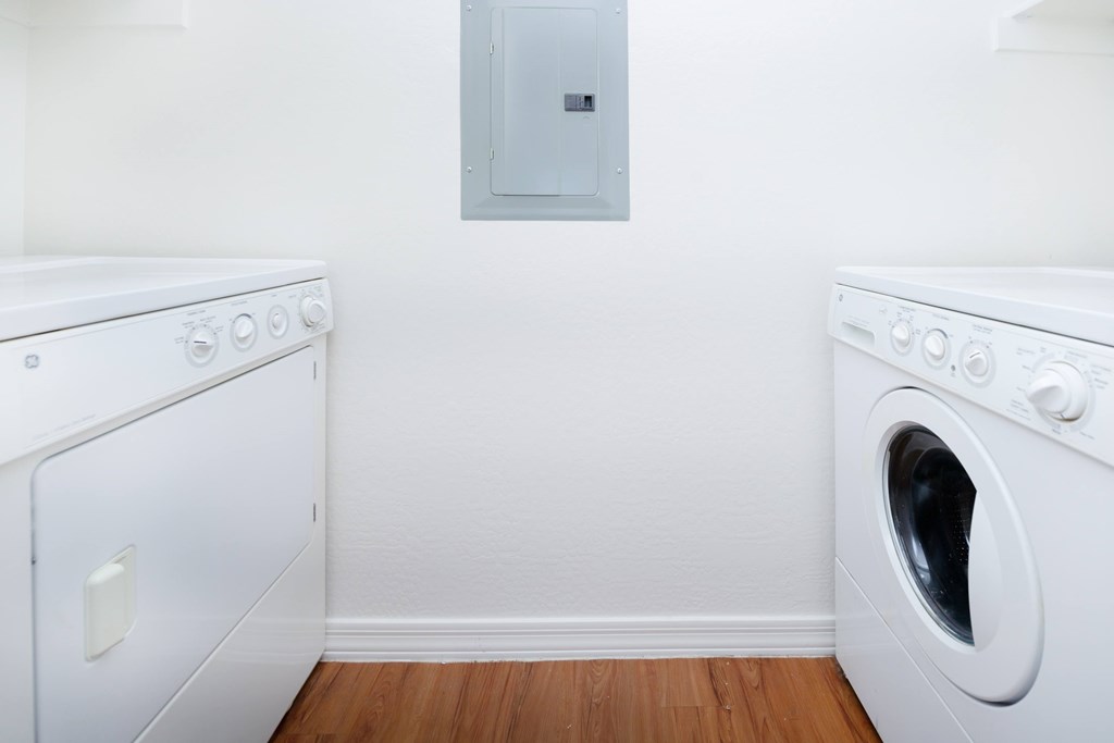 A white washing machine and dryer in a laundry room.