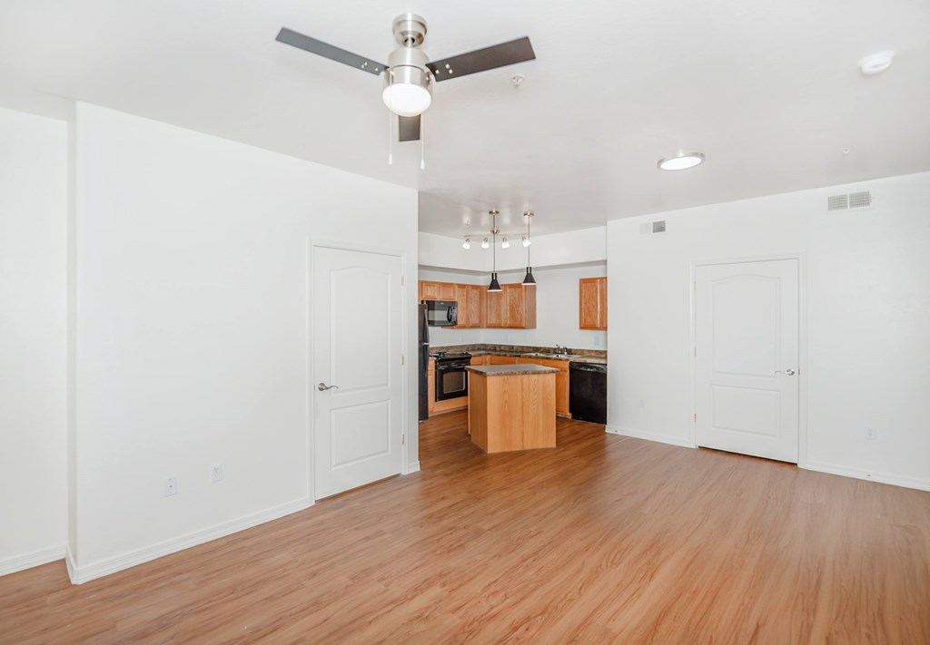 A room with a ceiling fan and wooden floors.