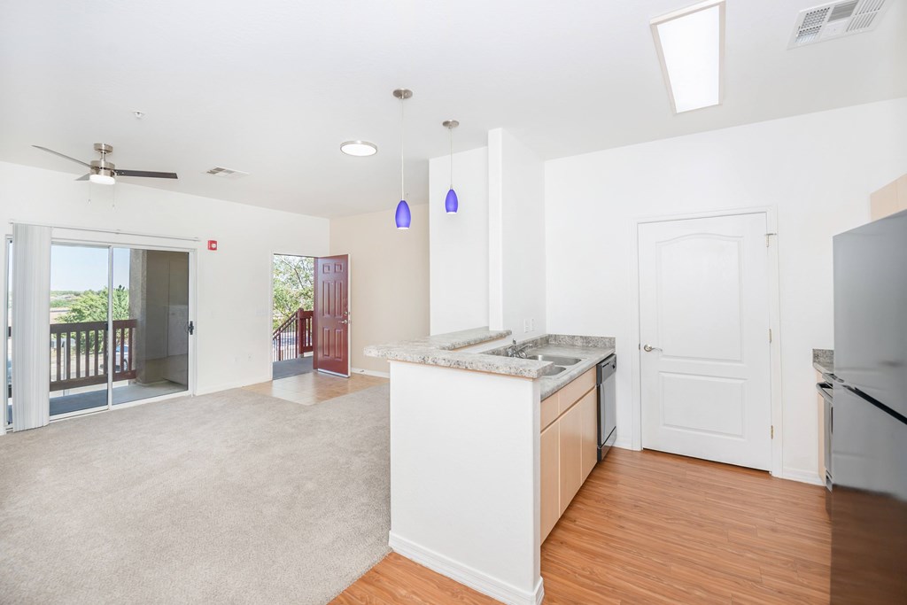 A kitchen with white cabinets and a wooden floor.