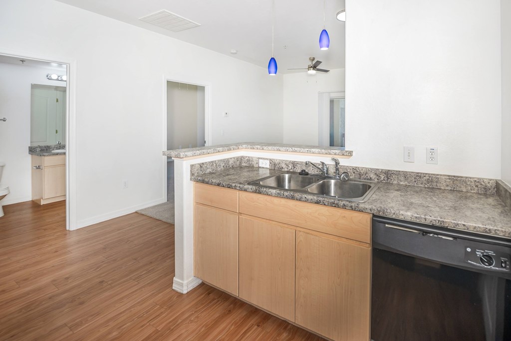 A kitchen with a granite countertop and wooden cabinets.