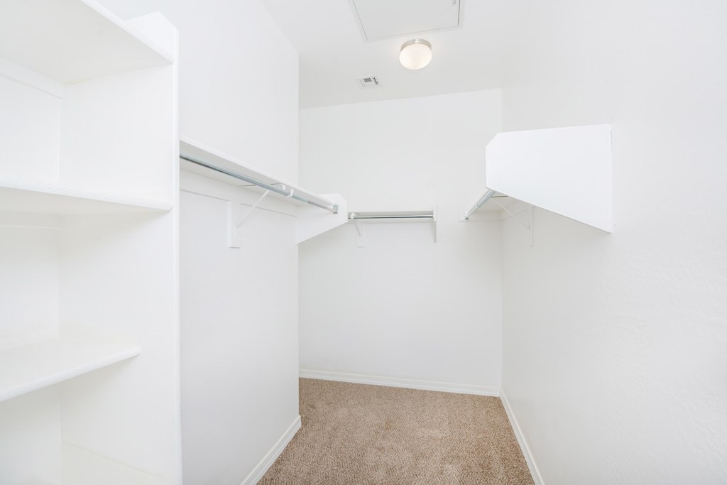 A small, empty room with white walls and a carpeted floor.