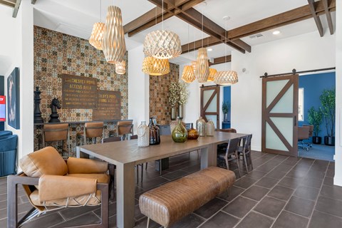 A dining room with a table and chairs and a wallpapered wall.