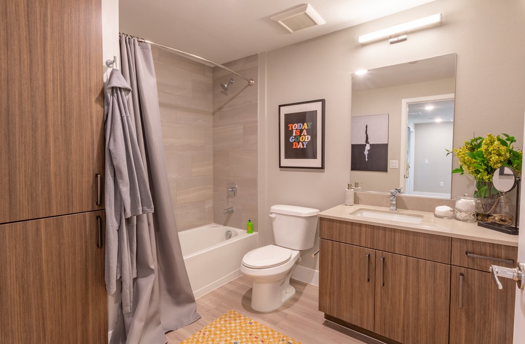 A bathroom with a toilet, sink, and a shower curtain.