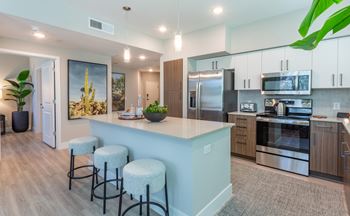 A kitchen with a bar area and stools.