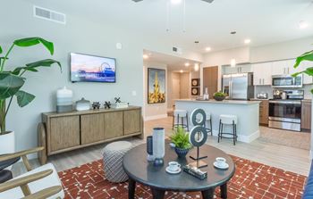 A modern living room with a flat screen TV mounted on the wall.