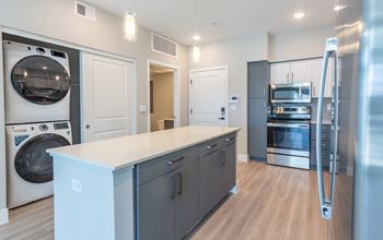 A modern kitchen with a washing machine and a refrigerator.