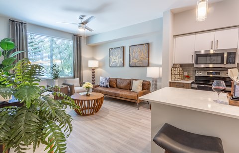 A living room with a brown sofa and a white counter.