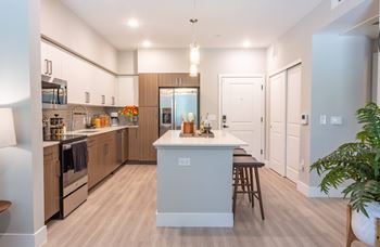 A modern kitchen with wooden cabinets and a central island.