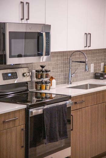 A kitchen with a stove, microwave, and oven.