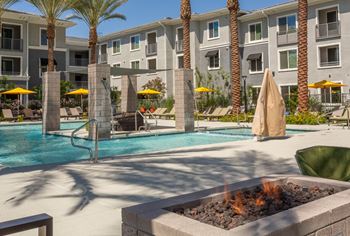 A pool surrounded by palm trees and umbrellas.